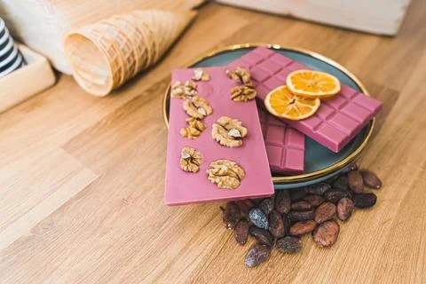 Various ruby pink chocolate bars with nuts, dried orange slices and toasted 写真素材