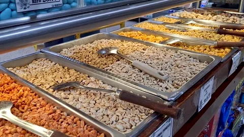 Various seasoned peanuts, corn, and nuts on display for retail Stock Footage 310742837