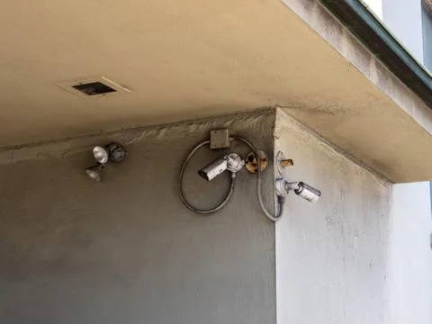 Various security cameras, lights and motion detectors outside building Fotos de archivo