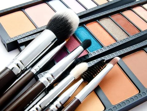 Various set of professional makeup brushes and palette of colourful eye shado Stock Photos
