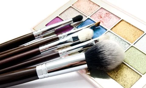 Various set of professional makeup brushes and palette of colourful eye shado Stock Photos