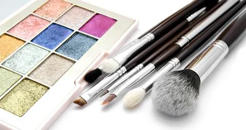 Various set of professional makeup brushes and palette of colourful eye shado Stock Photos