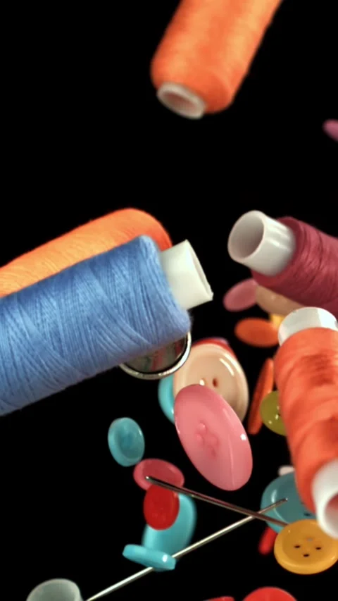 Various sewing accessories fly on a black background. Filmed on a high-speed Stock Footage 335376454
