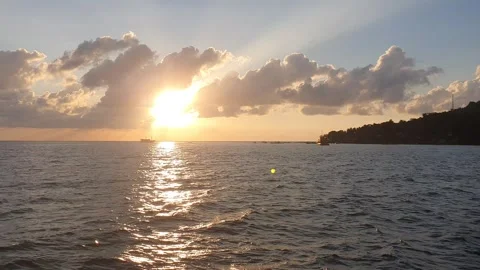 Various shapes of clouds in the sky as the sun rises over the sea Видео 336617889