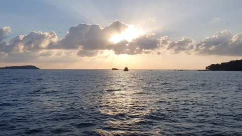 Various shapes of clouds in the sky as the sun rises over the sea Видео 336618113