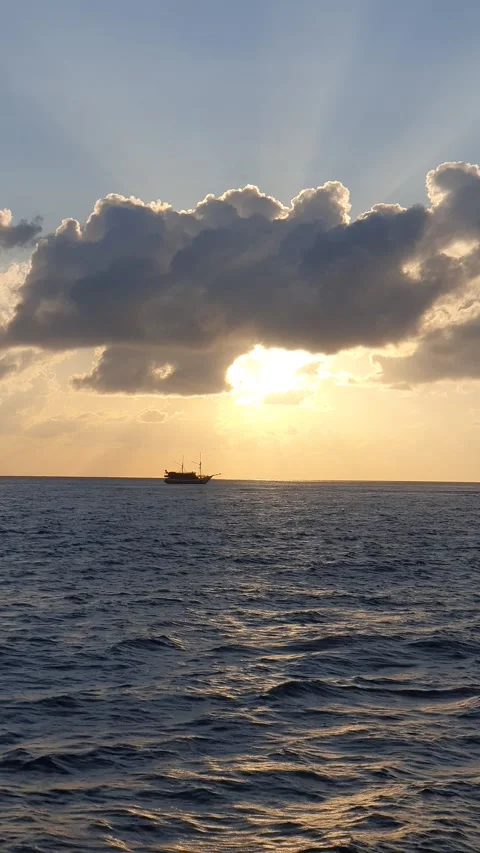 Various shapes of clouds in the sky as the sun rises over the sea Stock-Footage 336618292