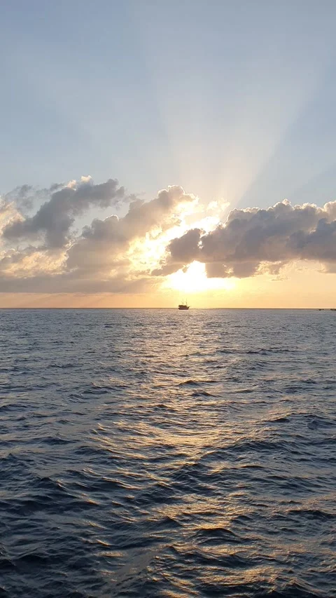 Various shapes of clouds in the sky as the sun rises over the sea 스톡 동영상 336618320