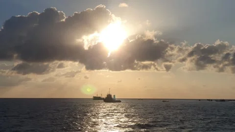 Various shapes of clouds in the sky as the sun rises over the sea Видео 336624848
