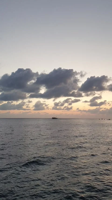 Various shapes of clouds in the sky as the sun rises over the sea Видео 336626557