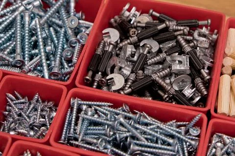 Various size and shape of screws, bolts, wooden pegs selection in red plastic Stock Photos