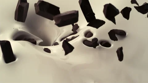Various size of chocolate pieces fall down into pouring creamy milk Stock Footage 147510715