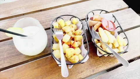 Various snacks including fried tofu and french fries on a wooden table Video stock 333634748