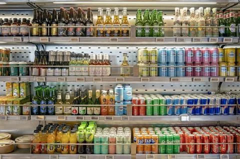 Various soft drinks and alcoholic beverages on store shelf Stock Photos