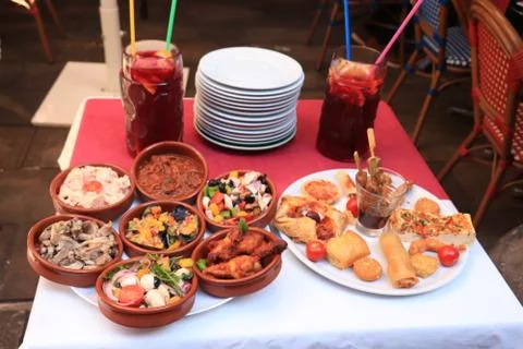 Various Spanish tapas in small plastic containers and fried tapas on a market Stock-Fotos
