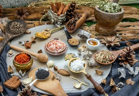 Various spices and herbs in rustic style with honey on balck background. Stock Photos