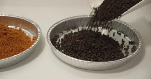 Various spices are added to the container. Packing of spices Video stock 230894397