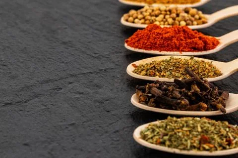 Various spices on dark background, with copy space. Stock Photos