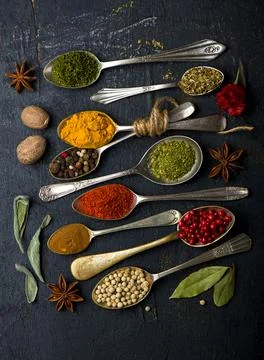 Various spices spoons on black table. Top view with copy space Stock Photos