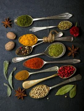 Various spices spoons on black table. Top view with copy space Stock Photos