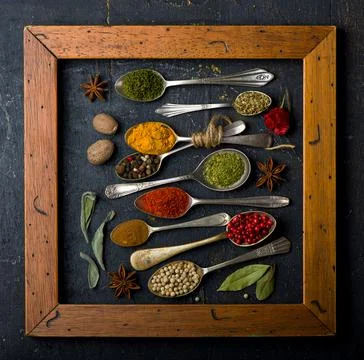 Various spices spoons on black table. Top view with copy space Stock Photos