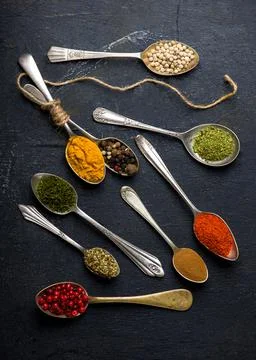 Various spices spoons on black table. Top view with copy space Stock Photos