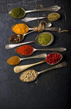 Various spices spoons on black table. Top view with copy space Stock Photos