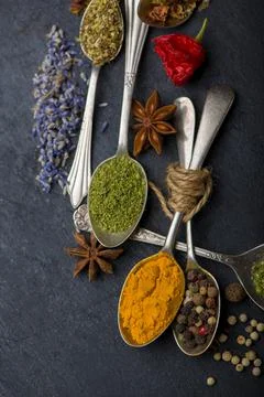 Various spices spoons on black table. Top view with copy space Stock Photos