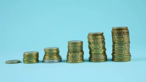 Various stacks of coins arranged in increasing order, on a blue background. 스톡 동영상 313937456