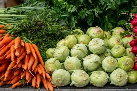 Various stacks of vegetables lie on the table for sale at the market Stock Photos