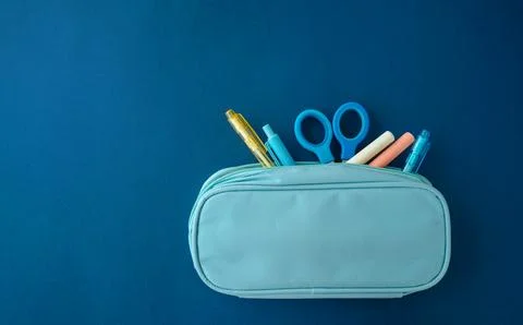 Various stationery tools in pencil case on blue background, school supplies.. Stock Photos