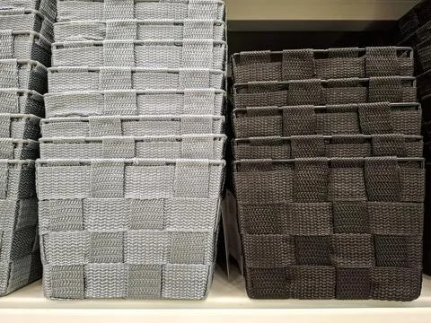 Various storage baskets in gray and black colors arranged on a shelf in a r.. Stock-Fotos