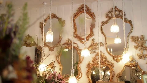 Various stylishly designed mirrors with gold frames hang on a wall with 스톡 동영상 132468459
