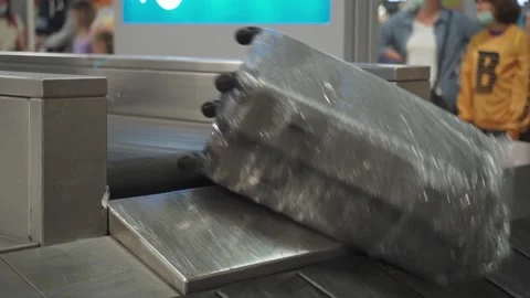 Various suitcases move along a baggage conveyor belt in the arrivals area of the Stock Footage 160926934
