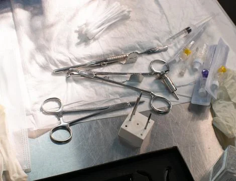 Various surgical instruments lie on the table. A sterile set of working Stock Photos