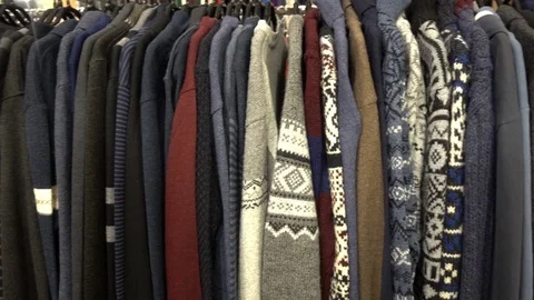 Various sweaters hang on hangers on the rack. Stock Footage 83024334