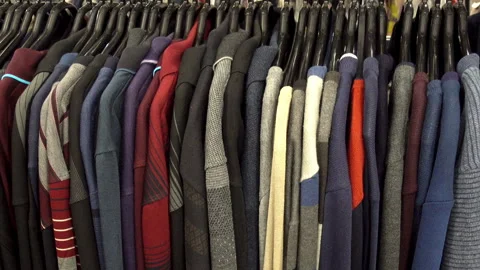 Various sweaters hang on hangers on the rack. HD video Stock Footage 101477502