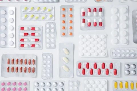 Various tablets and capsules in blisters on white background. Concept of heal Stock Photos