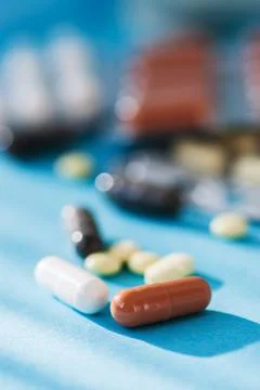 Various tablets, pills on blue background. Foto stock