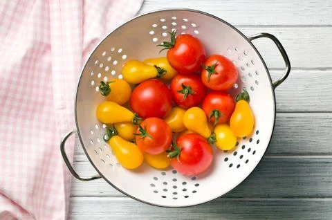 Various tomatoes in colander Stock Photos