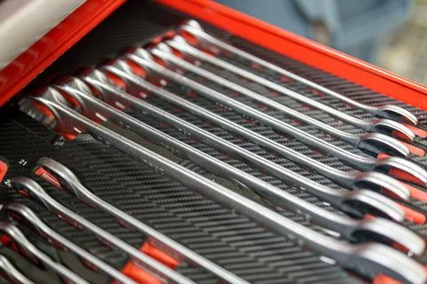 Various tools arranged in a red toolbox at a workshop during daylight hours Stock Photos