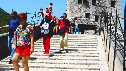 Various tourists passing over Old Bridge during sunny day in Mostar. Stock Footage 152954973