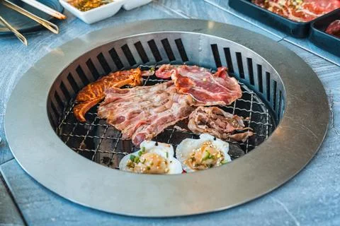Various type of raw beef slices grilling on BBQ grill in restaurant 스톡 사진