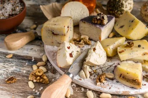 Various types of author's cheese, nuts and spices on a wooden background. Clo Stock Photos
