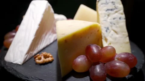 Various types of cheese and other delicacies on a rotating plate. Cheese plate Stock Footage 156950368