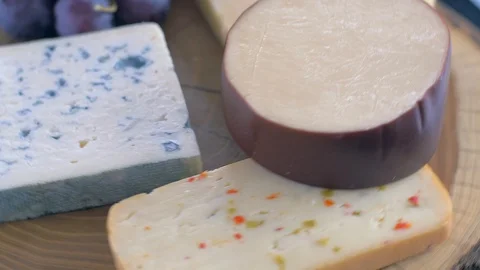 Various types of cheese are rotated on a wooden board Stock Footage 109127420
