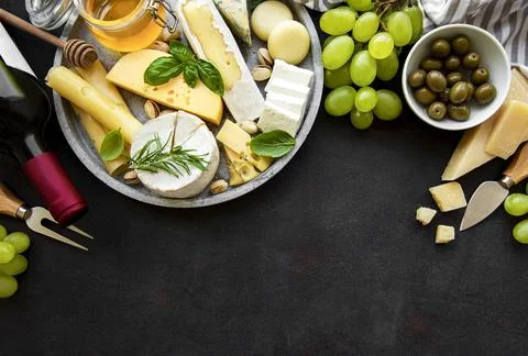 Various types of cheese, grapes, wine and snacks Stock Photos