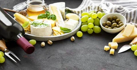 Various types of cheese, grapes, wine and snacks Stock Photos