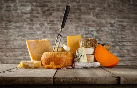 Various types of cheese placed on wooden table Foto stock