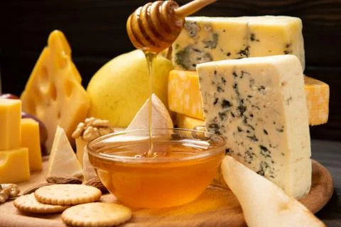 Various types of cheese on a rustic table Stock Photos