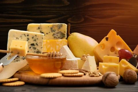 Various types of cheese on a rustic table Stock Photos